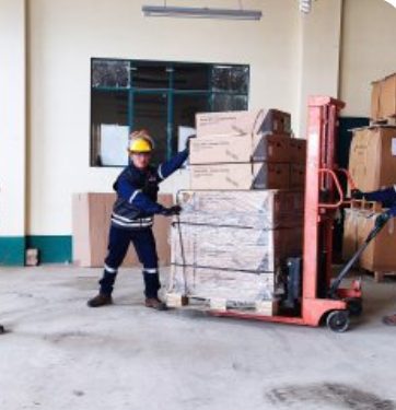 Técnico trasladando repuestos con una transpaleta en el almacén