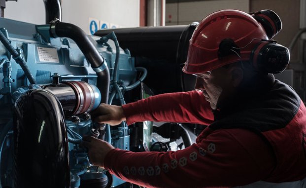 Técnico revisando el motor de un grupo electrógeno